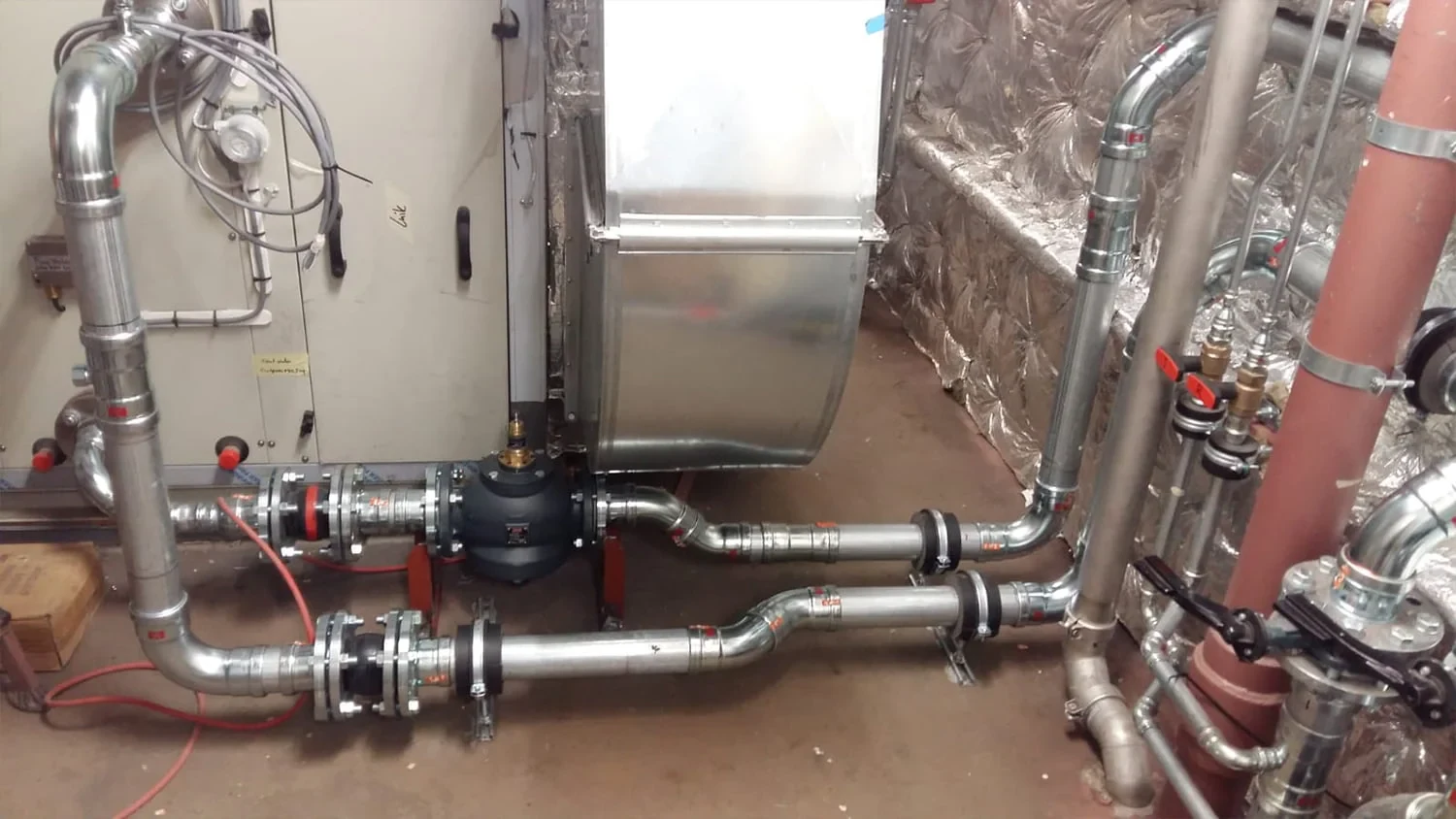 Small-bore pipework, valves and supports installed against a bulkhead on a cruise vessel in dry dock.