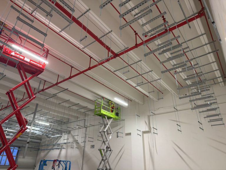 RAM project: Ceiling support channels and threaded rod hangers beside raised access platforms