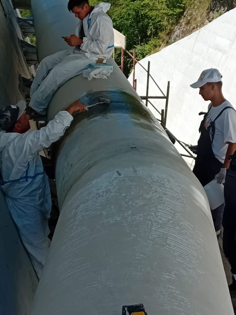 RAM project: Laminators applying resin and reinforcement to a pipe joint at Lesu Dam