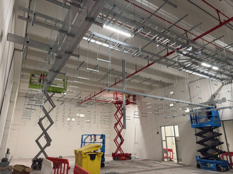 RAM project: Multiple crews installing overhead cable ladders and trays from scissor lifts