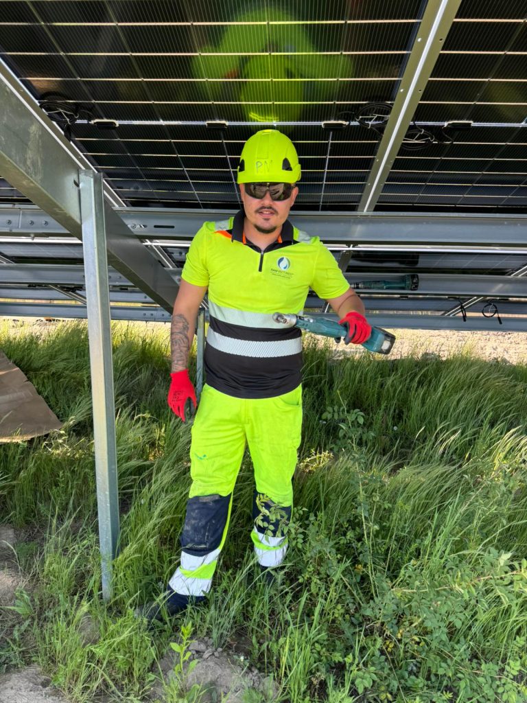 RAM worker beneath photovoltaic panels and steel mounting frames