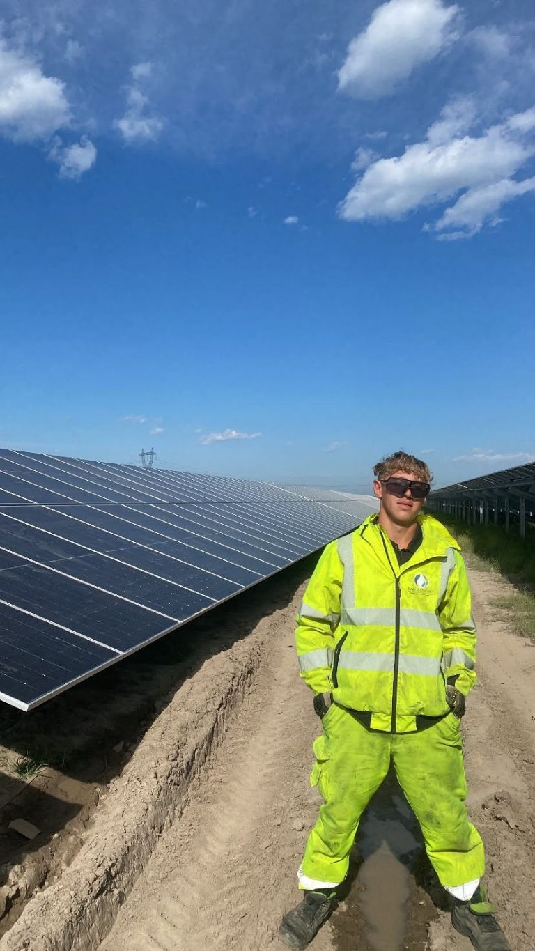 RAM worker beside rows of photovoltaic panels at Corbii Mari