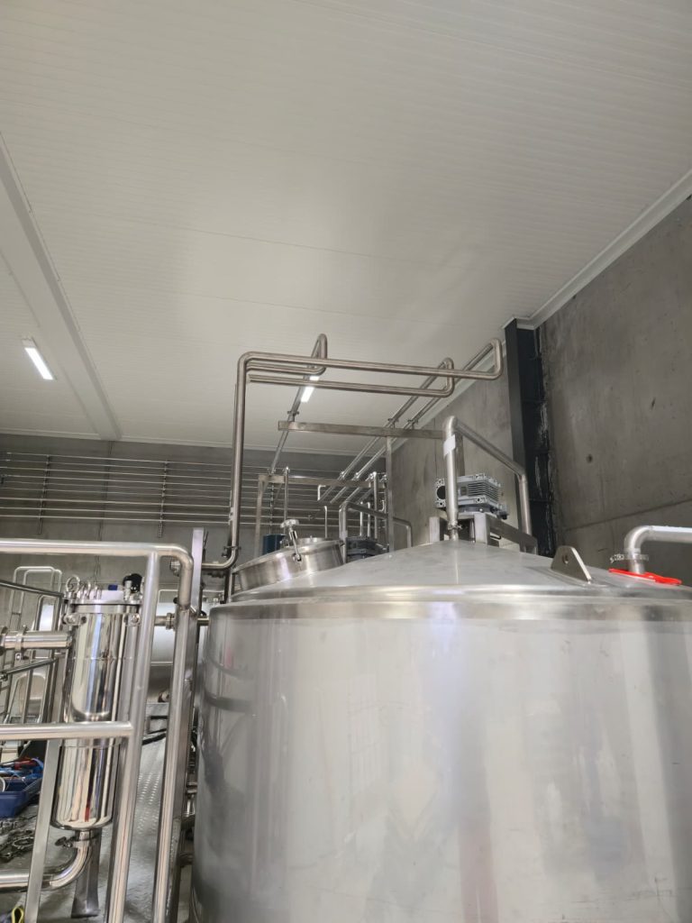 RAM project: Stainless steel brewery tank tops with motor drives and overhead pipe connections