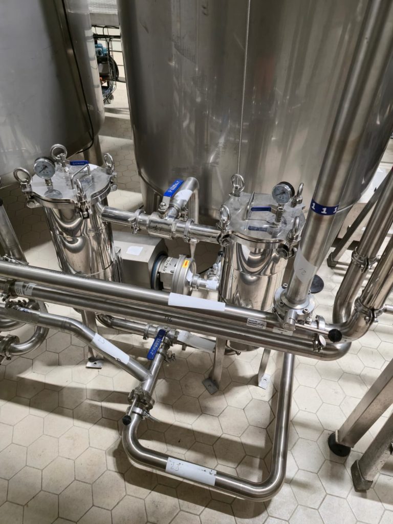 RAM project: Stainless steel filter housings, gauges and connecting pipework beside brewery tanks