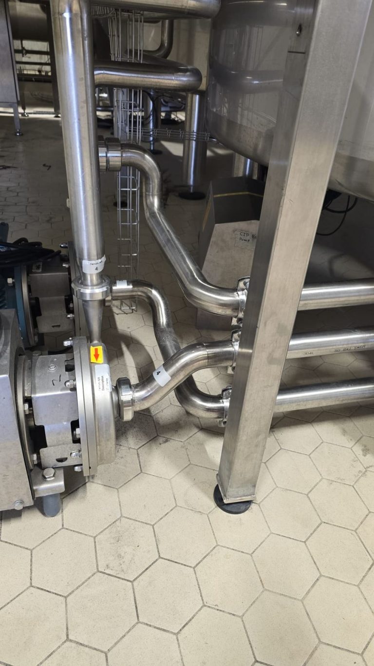 RAM project: Stainless steel pump connections and return pipework beside a brewery tank