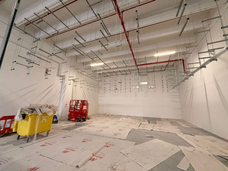 RAM project: Suspended containment supports and a red access lift in the data center hall