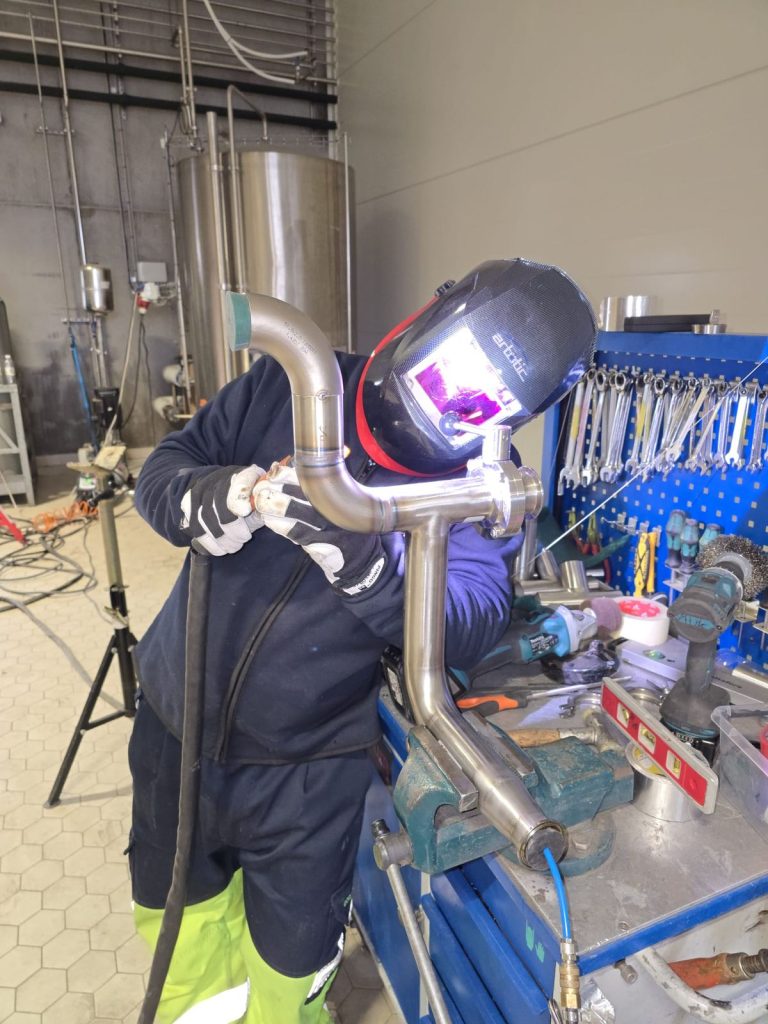 RAM project: Welder fabricating a stainless steel pipe assembly at the Danish brewery project