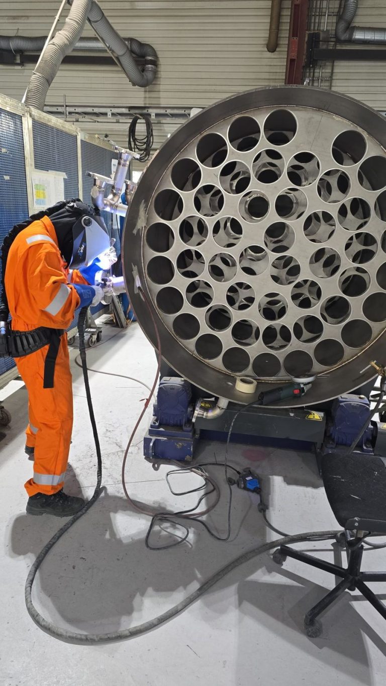RAM project: Welder working beside an open desalination tank and internal tube supports