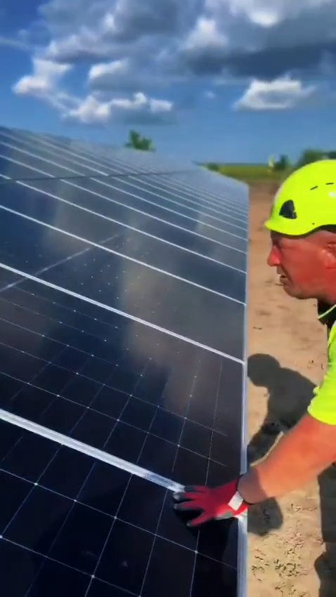 RAM crew positioning a photovoltaic module on a mounting structure